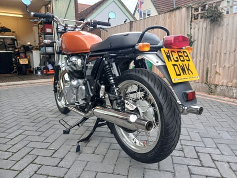 Three-quarter front view outside the garage, showing the chrome headlamp and front forks